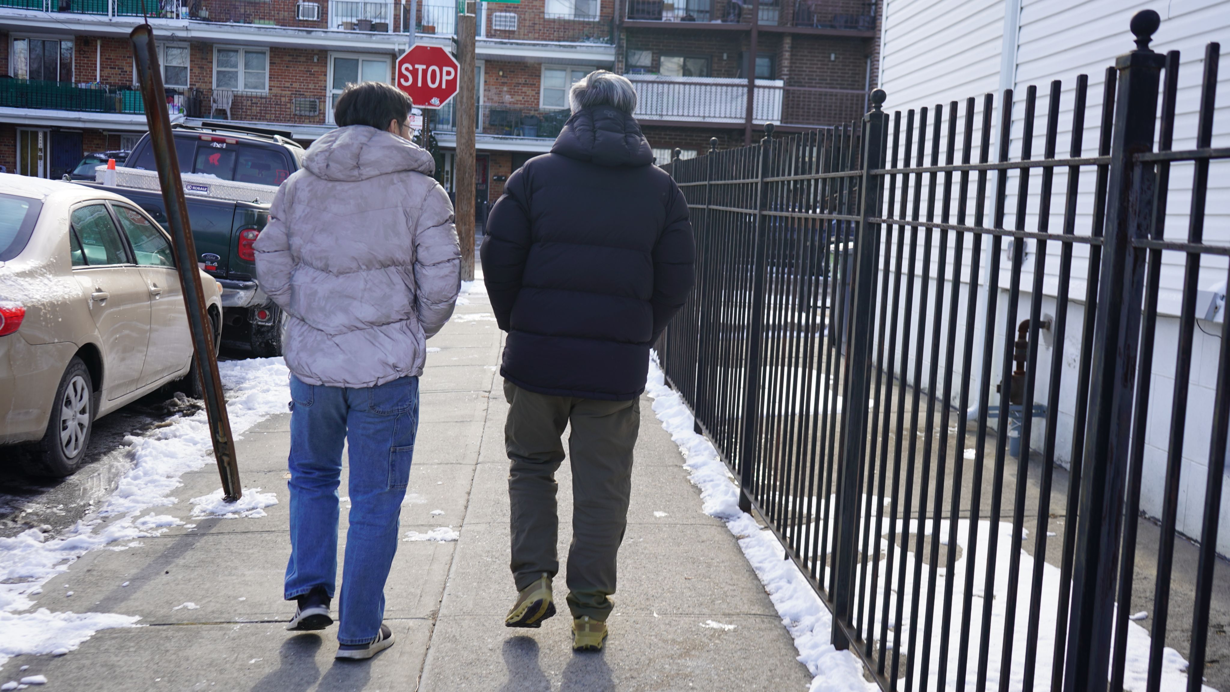 Ma Ju walks through Flushing with a current volunteer at the shelter.