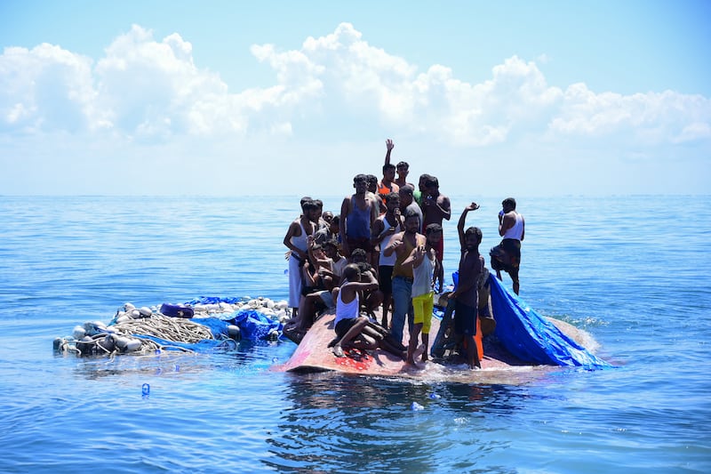 In this March 21, 2024, photo Rohingya refugees wait to be rescued from their capsized boat off west Aceh.