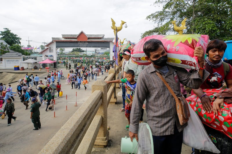 Cambodian migrant workers carry their belongings as they returned from Thailand through the Doung International Gate in Battambang province on July 28, 2025.