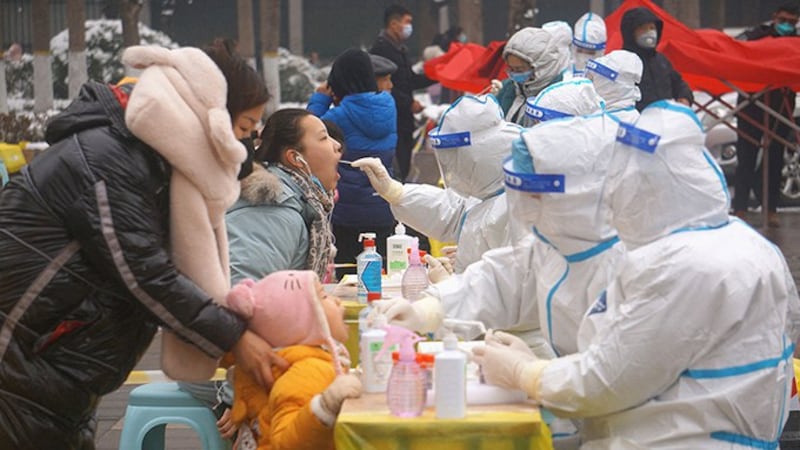 身着防护服的河南郑州医务人员2022年1月5日在全市范围内进行核酸检测(路透社)