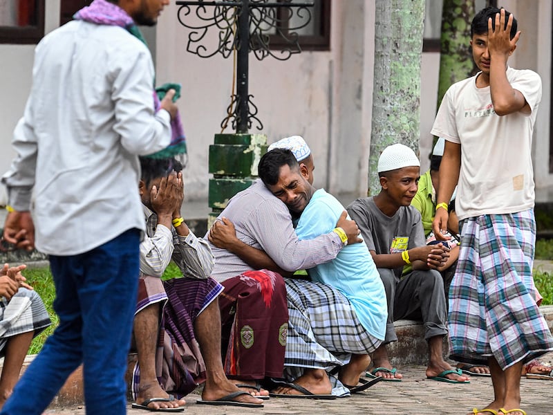 Rohingya refugees embrace each other after taking part in Eid al-Fitr prayers at a temporary shelter in Meulaboh, Indonesia, April 10, 2024.