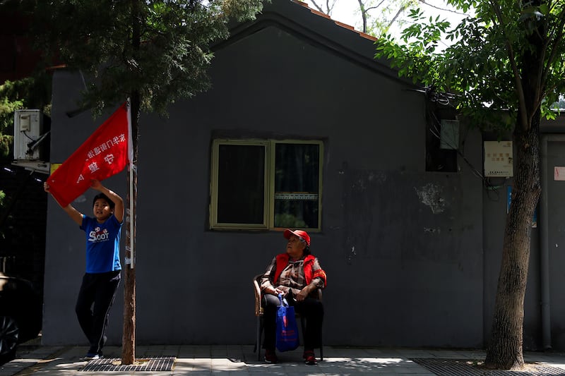 A member of a neighborhood party committee keeps watch along a street in Beijing, May 22, 2020.